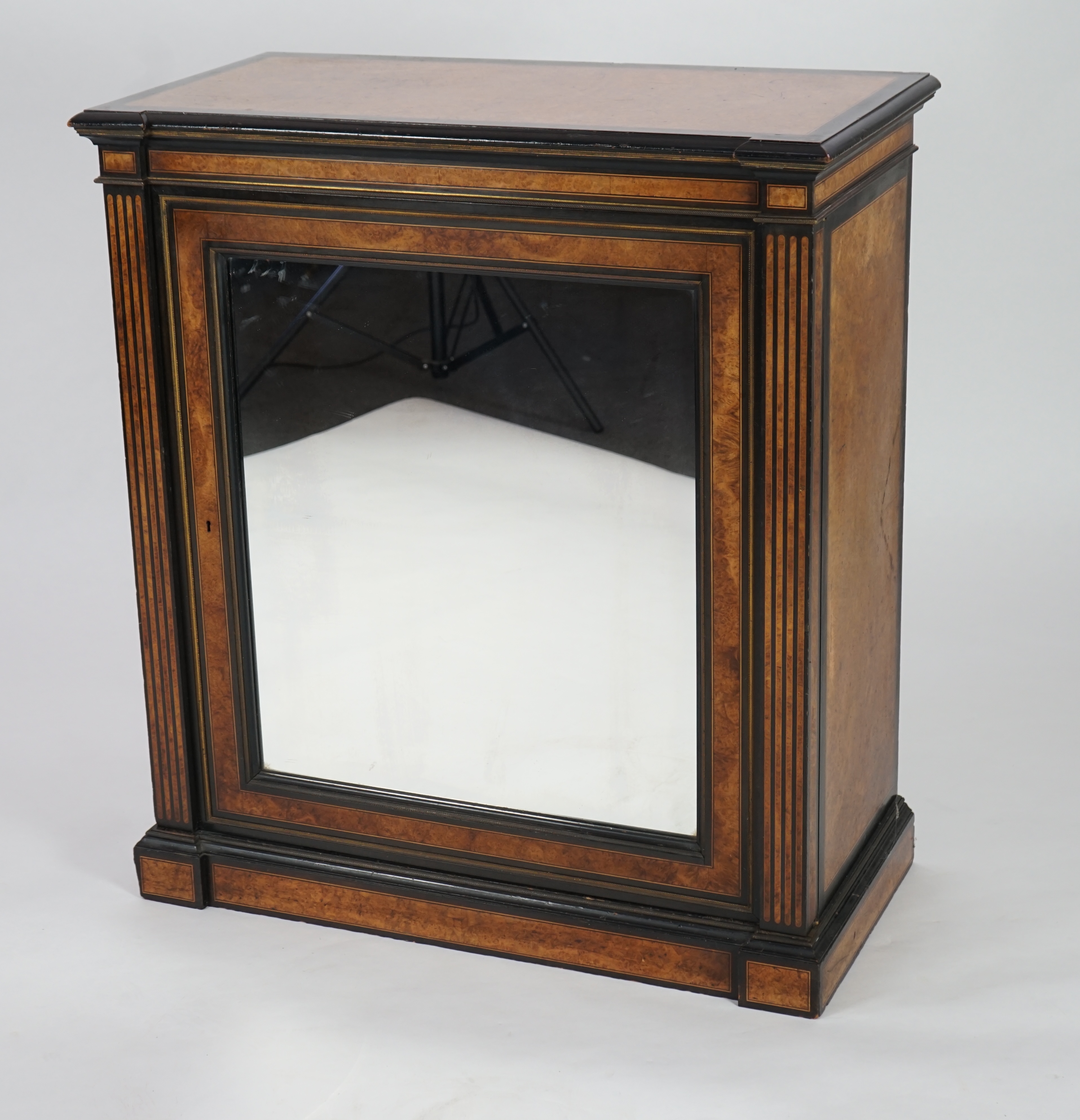 A Victorian ebony banded amboyna wood collector's cabinet, by Holland & Sons, with inverted breakfront top and single mirrored door enclosing four frieze and two banks of thirteen graduated drawers fitted with recessed b